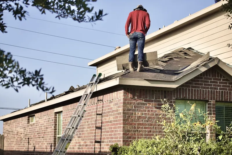 Professional roofer working on a residential roof in William Dunlap Homes